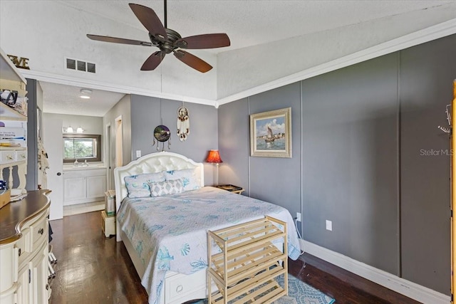 bedroom featuring connected bathroom, dark hardwood / wood-style flooring, a textured ceiling, lofted ceiling, and ceiling fan