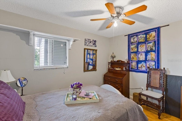 bedroom featuring a textured ceiling, ceiling fan, and hardwood / wood-style flooring