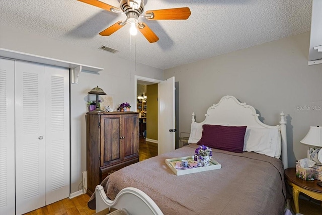 bedroom featuring a closet, ceiling fan, hardwood / wood-style floors, and a textured ceiling