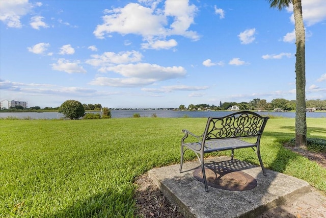 view of property's community with a lawn and a water view