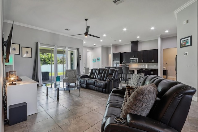 tiled living room featuring ceiling fan, sink, and ornamental molding