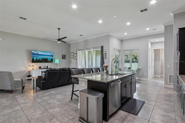 kitchen featuring ceiling fan, an island with sink, ornamental molding, sink, and dishwasher