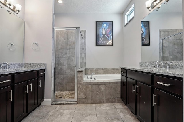 bathroom featuring vanity, shower with separate bathtub, tile patterned flooring, and a textured ceiling