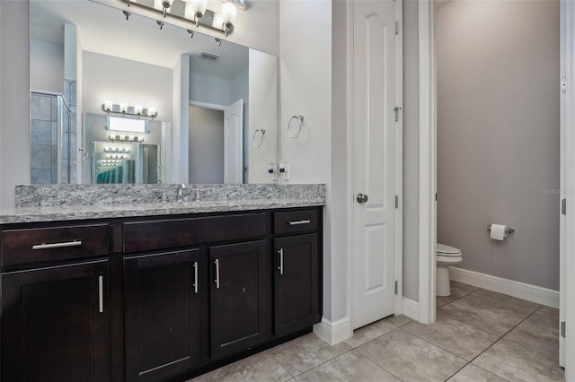 bathroom featuring vanity, a shower, tile patterned flooring, and toilet