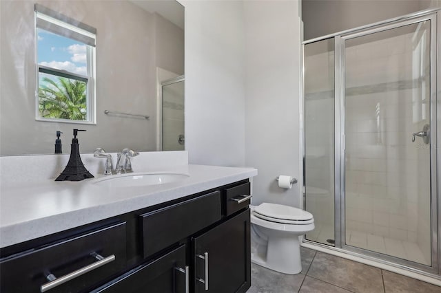 bathroom with walk in shower, vanity, toilet, and tile patterned floors