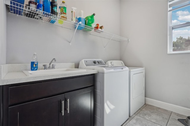 washroom featuring washer and clothes dryer, light tile patterned flooring, sink, and plenty of natural light