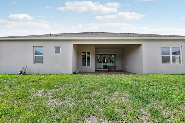 back of property featuring a patio and a yard