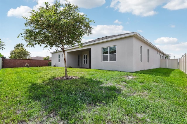 rear view of property featuring a yard