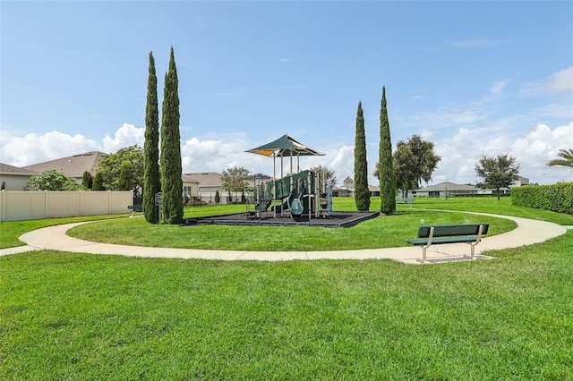 view of home's community featuring a playground and a yard