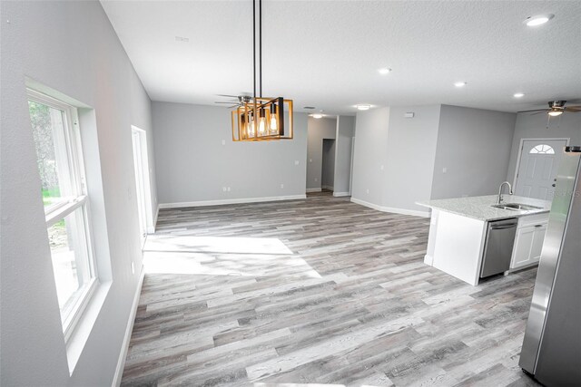 kitchen featuring appliances with stainless steel finishes, white cabinetry, ceiling fan, a healthy amount of sunlight, and sink