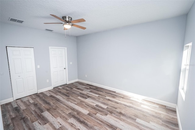 unfurnished bedroom with ceiling fan, hardwood / wood-style flooring, and a textured ceiling