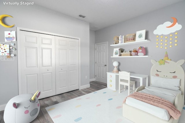 bedroom featuring a textured ceiling, dark wood-type flooring, and a closet