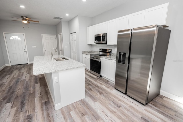 kitchen with white cabinetry, stainless steel appliances, ceiling fan, a kitchen island with sink, and sink