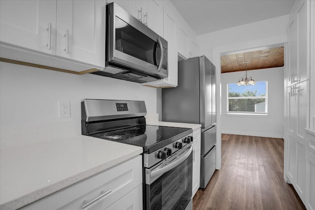 kitchen with white cabinets, an inviting chandelier, appliances with stainless steel finishes, and dark wood-type flooring