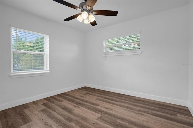 spare room with ceiling fan, dark hardwood / wood-style flooring, and a healthy amount of sunlight