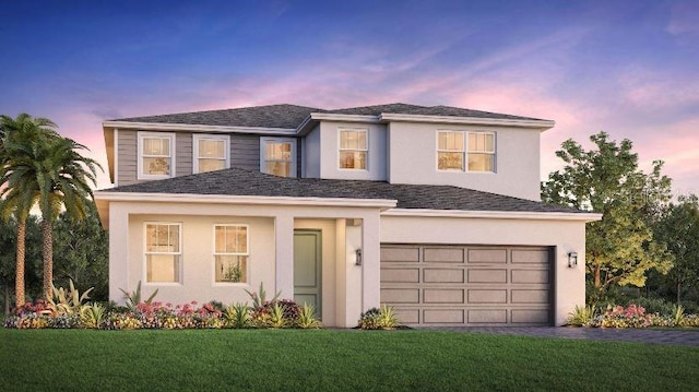 view of front of home with a garage and a yard