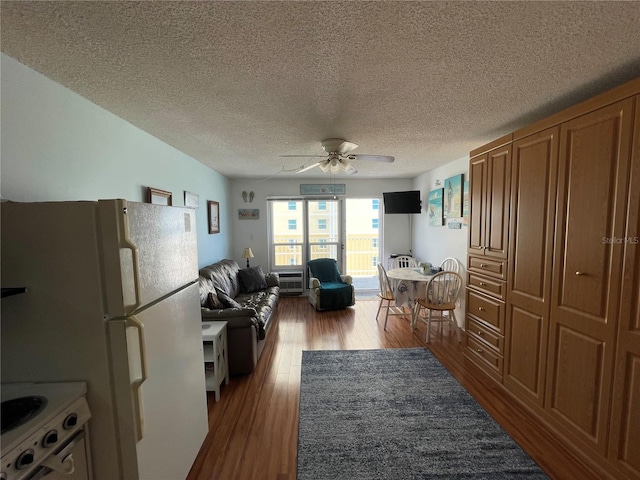 interior space featuring white appliances, ceiling fan, dark hardwood / wood-style flooring, and a textured ceiling