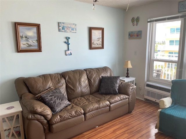 living room with hardwood / wood-style flooring and a wall mounted air conditioner