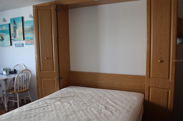 bedroom featuring dark wood-type flooring and a textured ceiling