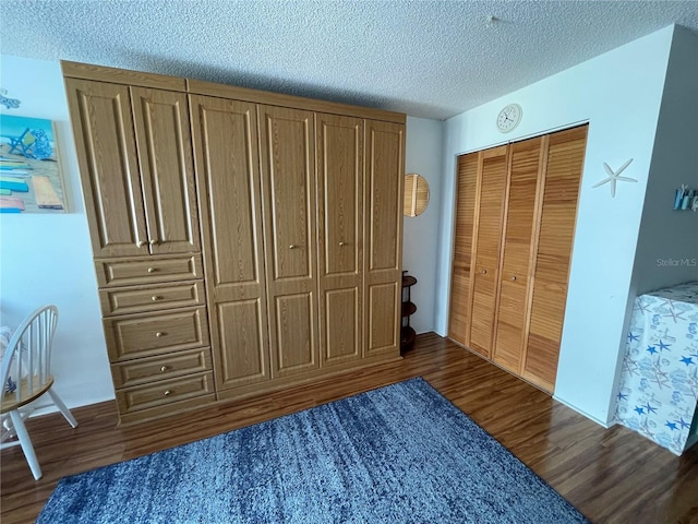 bedroom with a closet, dark hardwood / wood-style flooring, and a textured ceiling