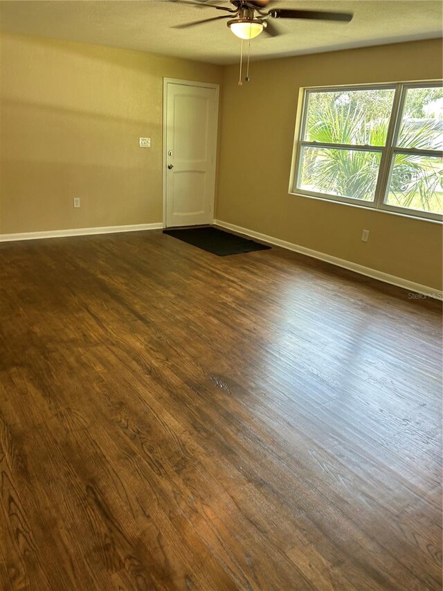 unfurnished room featuring ceiling fan and dark hardwood / wood-style flooring