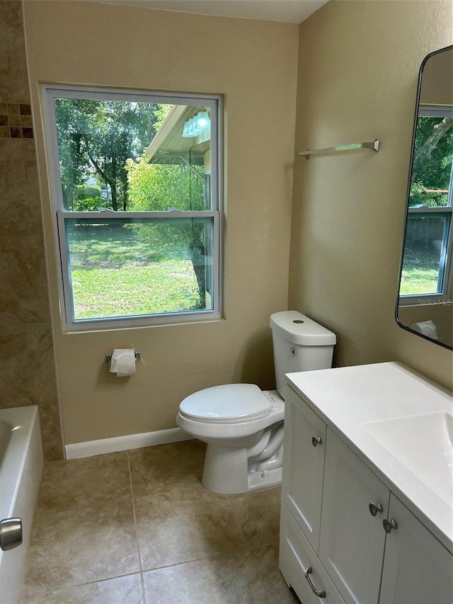 bathroom featuring vanity, a tub to relax in, tile patterned flooring, and toilet