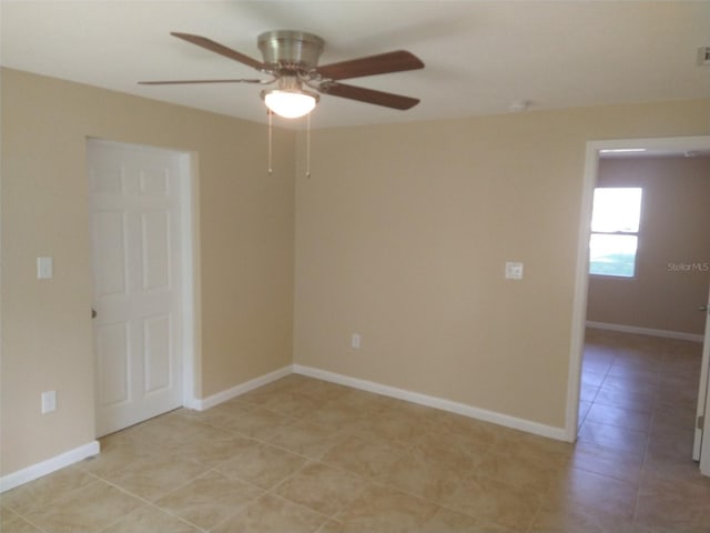 tiled spare room featuring ceiling fan