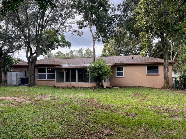 back of house with a yard and a sunroom