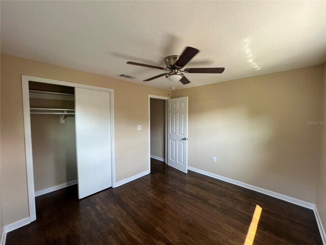 unfurnished bedroom featuring a closet, ceiling fan, and dark hardwood / wood-style floors