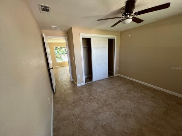 unfurnished bedroom with a closet, ceiling fan, and a textured ceiling