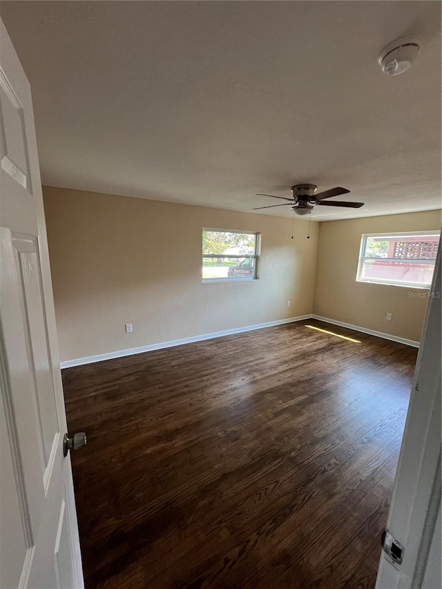 spare room with ceiling fan and dark hardwood / wood-style floors