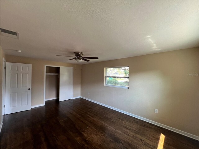 spare room featuring a textured ceiling, ceiling fan, and dark hardwood / wood-style flooring