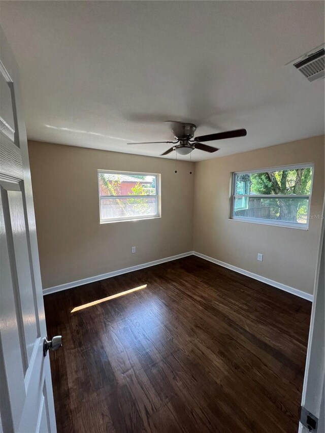 empty room featuring ceiling fan and dark hardwood / wood-style flooring