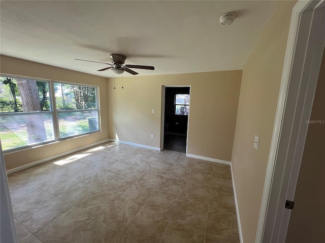 unfurnished room featuring ceiling fan and a textured ceiling