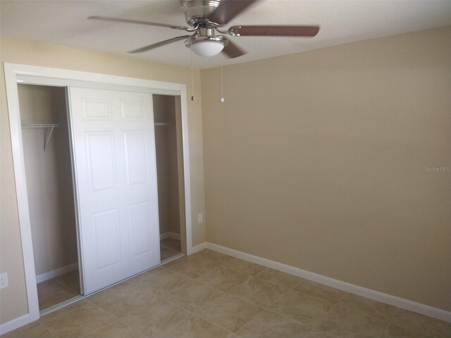 unfurnished bedroom featuring ceiling fan and a closet