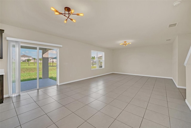 interior space with an inviting chandelier, plenty of natural light, and light tile patterned floors