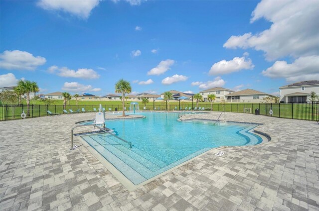 view of swimming pool featuring a lawn and a patio area