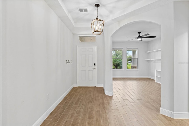 entrance foyer featuring light wood-type flooring and ceiling fan with notable chandelier