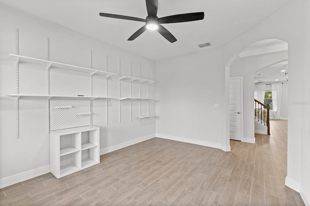 walk in closet with light wood-type flooring and ceiling fan