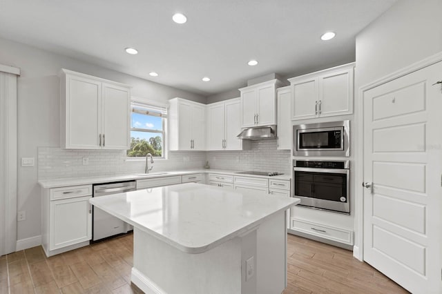 kitchen featuring light hardwood / wood-style flooring, a kitchen island, stainless steel appliances, and white cabinetry