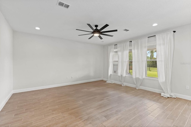 unfurnished room with light wood-type flooring, ceiling fan, and a textured ceiling