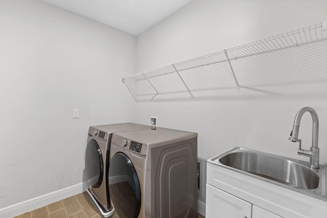 laundry area featuring cabinets, sink, and washing machine and dryer