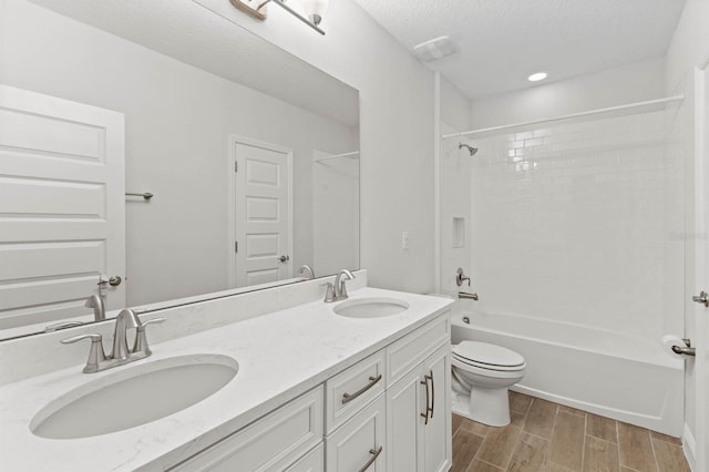 full bathroom with vanity, toilet, a textured ceiling, bathing tub / shower combination, and hardwood / wood-style floors