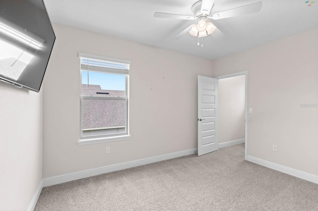 carpeted spare room with ceiling fan