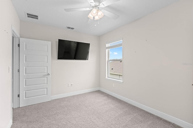 carpeted spare room featuring ceiling fan