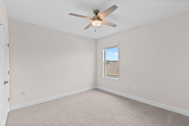 carpeted spare room with ceiling fan