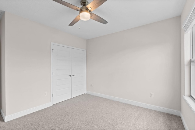 unfurnished bedroom featuring ceiling fan, a closet, and carpet