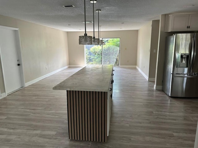 unfurnished dining area featuring a textured ceiling and wood-type flooring