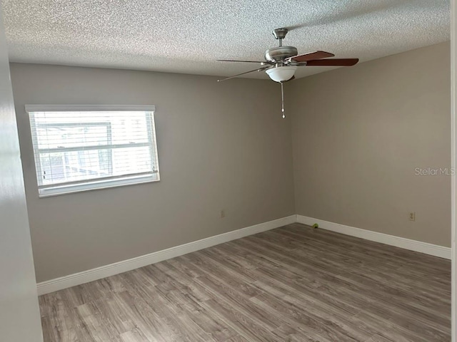 empty room featuring hardwood / wood-style floors, a textured ceiling, and ceiling fan