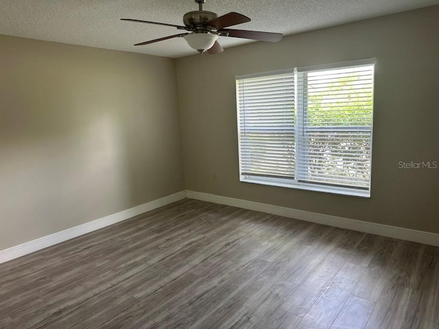 unfurnished room with ceiling fan, a textured ceiling, and dark hardwood / wood-style flooring